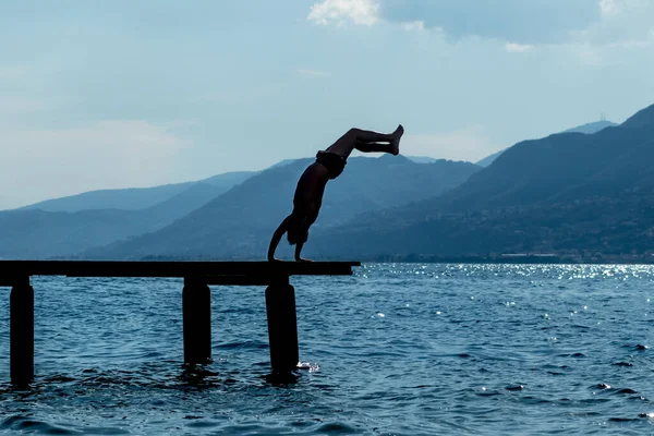 Una Silueta Hombre Saltando Lago Garda Mientras Realiza Una Parada — Foto de Stock