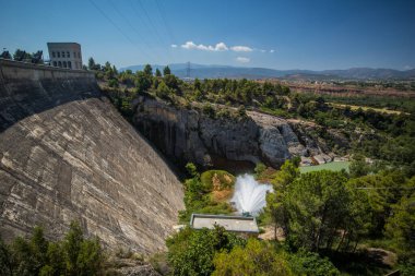Güneşli bir günde İspanya 'nın Katalunya kentindeki Tremp şehrine yakın Talarn Gölü' ndeki bir hidroelektrik santralinin panorama resmi..