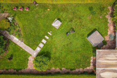 Robot çim biçme makineleri için kablo döşeyen bir operatörün havadan çekilmiş fotoğrafı. Robot çim biçme makinesi için kılavuz kablo olarak toprağa yerleştiriliyor