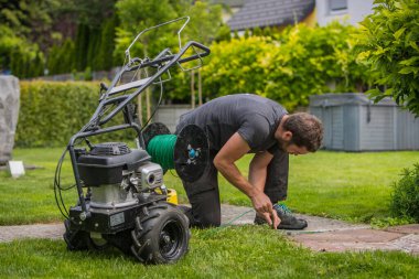 Robot çim biçme makineleri için kablo döşeyen bir operatörün olduğu kablo döşeme makinesi. Robot çim biçme makinesi için kılavuz kablo olarak toprağa yerleştiriliyor