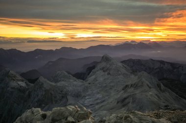 Sabahın erken saatlerinde Slovenya 'nın en yüksek dağı olan Triglav' dan izlendi. Görünür güneş vadilerin ve dağ sıralarının üzerinde yükseliyor ve parlıyor.