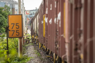 Yük treni bir insana çarpıp ezerken durdu. Raylarda ölüm, kurtarma görevlileri ve itfaiyeciler trenin altında mahsur kalan kişiye ilk yardım yapılmasına yardım ediyorlar..