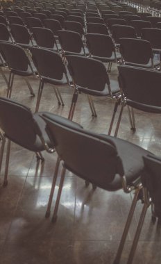 Konferans salonundaki modern koltukların eski bir fotoğrafı. Bir konferansta ya da toplantıda birden fazla sandalye