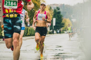LJUBLJANA, SLOVENIA, 28. Ekim 2018: 23 'te koşucular. Ljubljana maratonu yağmur birikintileri ve suyla mücadele ederken, gece boyunca sağanak yağış sonrası engeller olarak görülüyor..