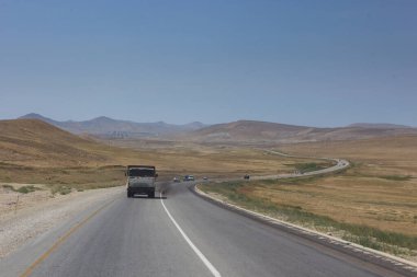 Bakü 'ye giden Azerbaycan' daki yola bakan bir manzara. Azerbaycan kırsalında asfalt yolda trafik var..