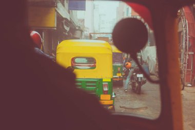 Yeni Delhi 'nin Hindistan sokaklarında bir Tuk tuk ya da rikshaw' a bin. Delhi 'yi kirleten trafikte çılgın bir yolculuk. Renkli tribünler Hindistan 'ın yoğun kirli havasında yol alırlar..