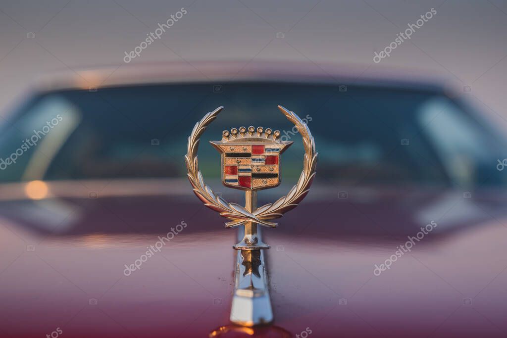 LEVEC, SLOVENIA, 20. OCTOBER 2018: Cadillac logo or coat of arms on a hood of a red old vintage limousine with windshield visible.