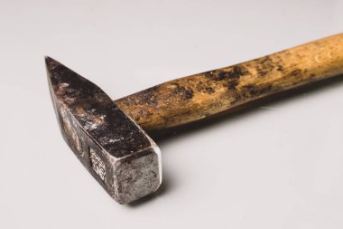 Kullanılmış ve kullanılmış, tahta saplı ve metal uçlu Avrupa tarzı bir çekiç. Beyaz yansıtıcı panoya izole edilmiş.