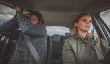 A woman is calmly driving a car and a man in the next seat is scared as hell. Totally scared co-driver because of reckless careless driving by a woman. clipart