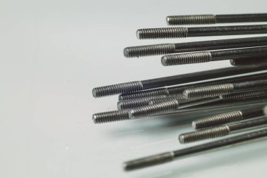 Bisiklet telleri. Beyaz yansıtıcı arka planda yerde duran bisiklet tellerinin başlıklı bir kısmının makro fotoğrafı. Tel yığınları kurulmaya hazır.