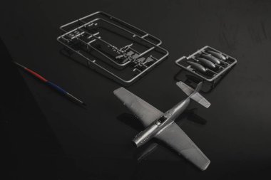 Plastik model uçak reçine setinin parçaları. Bir çerçevede birleştirilmeyi bekleyen plastik model uçak parçaları.
