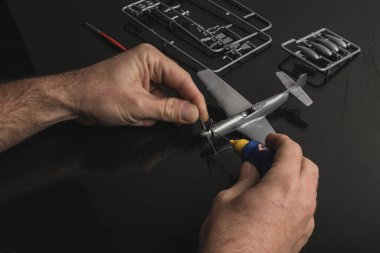 Plastik model uçak reçine setini yapıştırıcıyla birleştirmenin ayrıntıları. Plastik model uçağın parçalarını yapıştırmak için kullanılan çimento yapıştırıcısı..