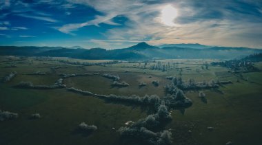Slovenya, Avrupa 'daki Planinsko polye sahasının soğuk kış ortamına ait destansı hava manzarası. Resmedilmeye değer soğuk kış manzarası. Kışın güneşle aydınlanan çayırlarda ve tarlalarda kar yok..
