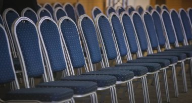 Toplantı ya da konferans sırasında beyaz noktalı ve alüminyum çerçeveli mavi sandalyeler. Modern mavi sandalyeler konferans salonunda..