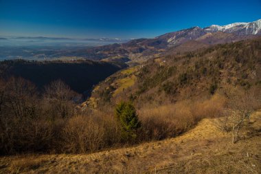 Slovenya 'nın Kamnik kentinin hemen yukarısındaki Karavanke Alpleri' nde tanınmış bir yürüyüş yeri olan Sveti Primoz 'daki kilisenin manzarası. Bulutlarda görünen Ljubljana ve Kamnik havzası.