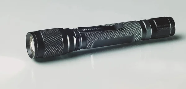 LED torch made of black anodised metal or aluminium. Modern LED hand torch on a white background.