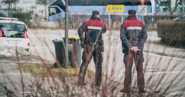 City rangers or redar on a mission to stop and fine speeding cars. Speed control in the city with uniformed people or police officers. Back view of officers stopping too fast cars.