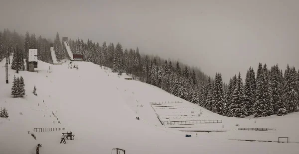 放棄されたスキーのパノラマビューは 1984のオリンピックの会場であるIldzaのIgman山でジャンプします 古いスキージャンプのぼんやりと霧のパノラマ — ストック写真