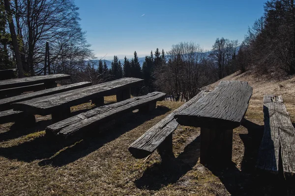 Wooden benches for hikers and bicyclists on the top of the hill with a nice view towards the valley. Lookout point with a bench.