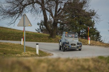 JANCE, SLOVENIA, 16.3.2019: Gri bir vintage Citroen 2CV arabası, kötü şöhretli yumuşak süspansiyon ayarları nedeniyle çarpıcı bir eğriye eğiliyor.