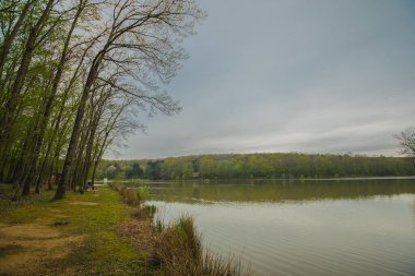 Slovenya 'nın Prekmurje kentinde bulunan Bukovnisko jezero ya da göl kıyısındaki santrallerin hava bulutlu bir ilkbahar gününde görüntülenmesini.