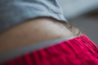 Detail of black male hair on lower back or just above the ass. Man showing his hair on the back.