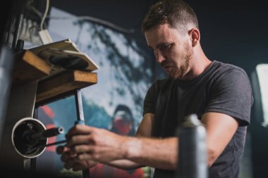 Profesyonel tamirci vidayı gevşetmek için anahtarı kullanarak dış motoru tamir ediyor. Süslü bir atölyede tekneyi tamir eden adam.