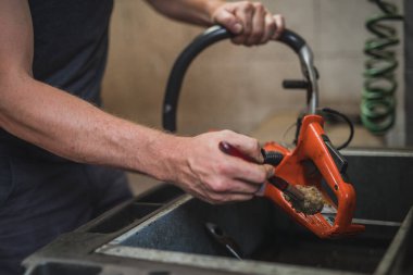 Elektrikli testereyi temizleyen adam