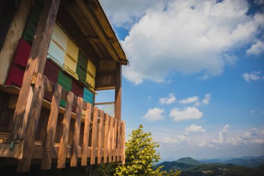 Eski ahşap ev, modern arı kovanı görevi görüyor. Güneşli bir günde ortaya çıkan arılarla dolu renkli kovanları.