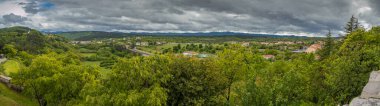 Panoramic view from the village of Stanjel, Slovenia, on a cold cloudy spring day with dense clouds covering the sky. clipart