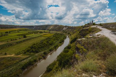 Güneşli bir yaz gününde Moldova 'daki Orheiul Vechi manastırındaki güzel kaya ve ağaç manzarası. Manastıra ve çan kulesine doğru bakın.