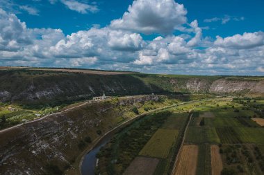 Güneşli bir yaz gününde Moldova 'daki Orheiul Vechi manastırında kayalardan ve ağaçlardan oluşan insansız hava aracı panoraması. Manastıra ve muhteşem manzaralı çan kulesine bakın..