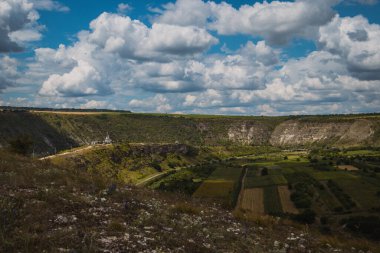 Güneşli bir yaz gününde Moldova 'daki Orheiul Vechi manastırında kayalardan ve ağaçlardan oluşan insansız hava aracı panoraması. Manastıra ve çan kulesine doğru bak..