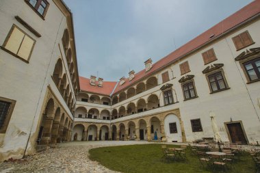 Beautiful courtyard with arches of the Ptuj castle. Facade and main square of Ptujski grad on a dull autumn day. clipart