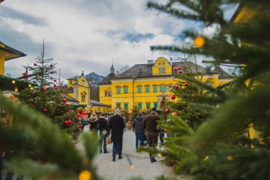 Sonbaharın sonlarında Heilbrunn Sarayı 'ndaki insanlar noel panayırı ya da Noel' in başında. Kale, ağaçlar ve diğer gelişen etkinliklerle çevrili taşra bölgesinde görülüyor..