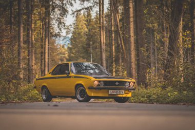 BRNIK, SLOVENIA, 28.10.2019: Güz ormanlarında sokağa park edilmiş sarı renkli klasik Opel Manta A GT / E arabası.