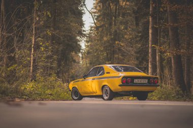 BRNIK, SLOVENIA, 28.10.2019: Güz ormanlarında sokağa park edilmiş sarı renkli klasik Opel Manta A GT / E arabası.