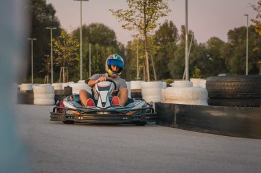 Adam kapalı devrede ticari amatör gokart yarışında yarışıyor. Eğlenceli yarış aktiviteleri, arkadaşlar arasında kart kupası..