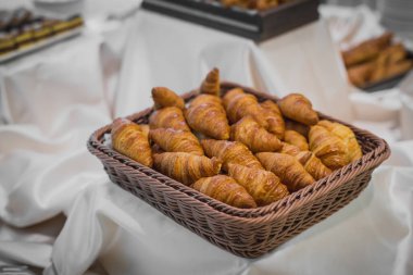 Bir galada ya da bir ziyafette sergilenen sepetteki taze kruvasanlar..