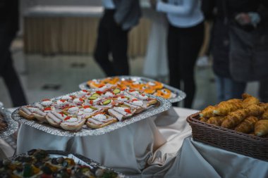 Bir galada ya da bir partide gümüş bir tabakta farklı atıştırmalık ve sandviçler koleksiyonu..