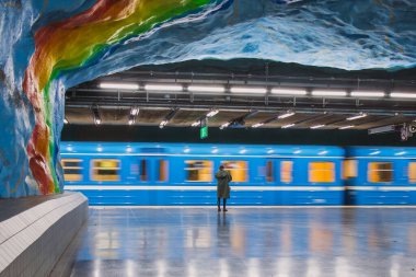 Stockholm 'deki stadyumun metro istasyonunda bir kişi bekliyor. Metro polisi hareket bulanıklığıyla emsalinin yanından geçiyor. Toplu taşıma kavramı