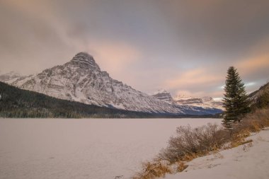 Kasım ayı sonlarında sabahın erken saatlerinde Chephren Dağı 'nın manzarası. Donmuş gölün üzerinde yükselen güzel dağ.