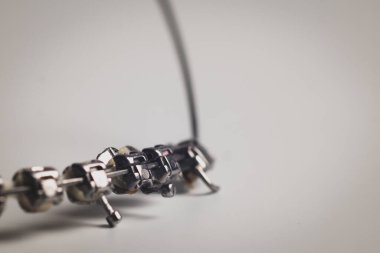 Dişsiz diş tellerinin makro fotoğrafı, ağızdan sökülmüş, resimde kimse yok. Kemer, kablolar, yaylar ve beyaz arkaplanda izole edilmiş diş telleri.