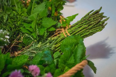 Taze yeşil kuşkonmaz sıkıca dokunmuş ve diğer bitkilerin arasına sıkıştırılmış..