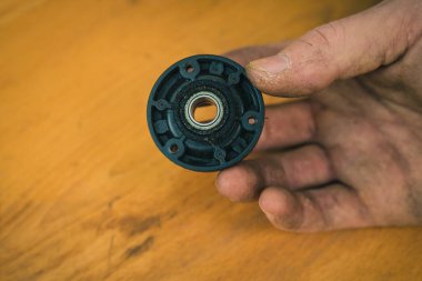 Motorlu robot çim biçme makinesinde bulunan eski bir bıçak diski. Kirli ve paslı çim biçme bıçağı yenisiyle değiştirilmeye hazır