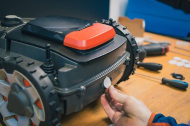 Robot çim biçme makinesi için filtre ya da neopren solunum cihazını değiştiriyorum. Modern otonom çim biçme makinesi için su geçirmez mühür değiştiriliyor..