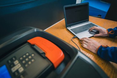 Modern robotik çim biçme makinesi yıllık hizmette servis tanılama ve yazılım güncellemesi kapsamında bir bilgisayar veya dizüstü bilgisayara bağlanıyor