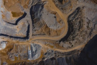 Slovenya 'nın Verd kentinde güneşli bir günde açık mayın veya taş ocağının dikey drone panoraması. Görünür teraslar ve aşağıya bakan engin kum ve taş yüzeyi ilginç şekiller ortaya çıkarıyor..