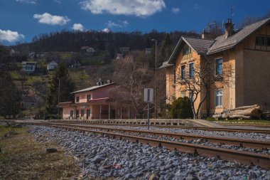 Slovenya 'nın eski boş tren istasyonu, güneşli bir baharda hiçbir tren ya da yolcu görünmüyor.