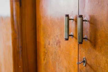 Eski bir ahşap mobilyanın kapı kolu, kilidi ve sapı. Görünür bir kilit ve eski ahşap bir kapının anahtarı.